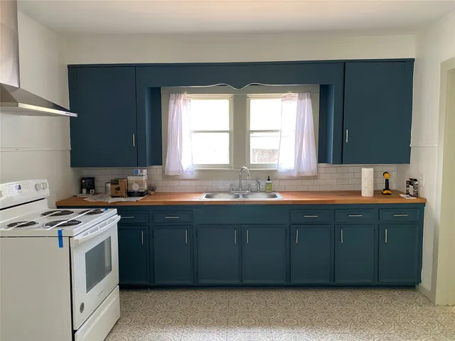 a kitchen with a sink stove and cabinets