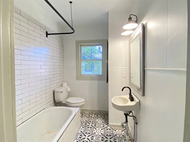 a bathroom with a sink a toilet and mirror