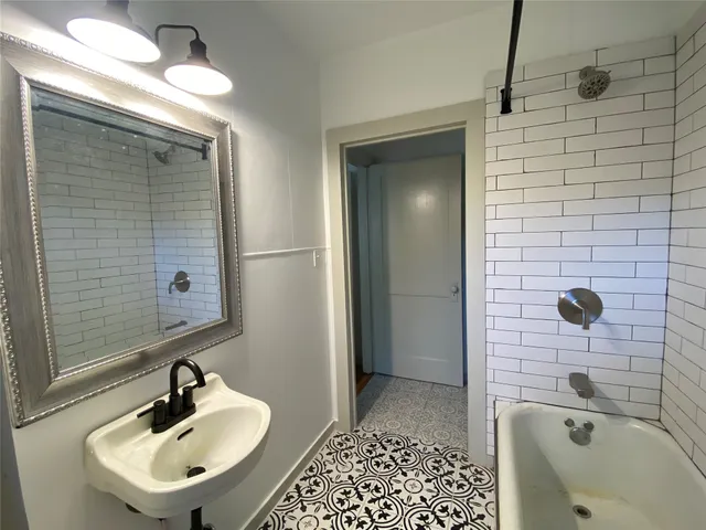a bathroom with a sink a shower and a mirror