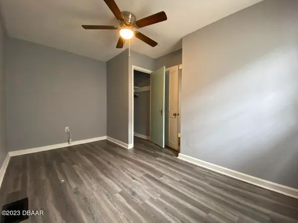 an empty room with closet and a ceiling fan