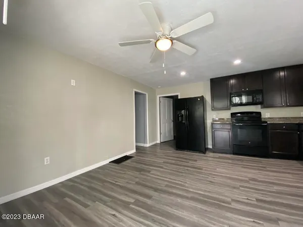 a view of kitchen with refrigerator and microwave