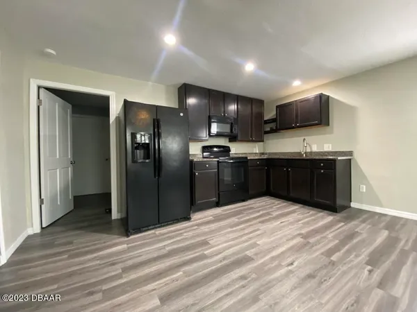 a kitchen with stainless steel appliances granite countertop a sink and a refrigerator