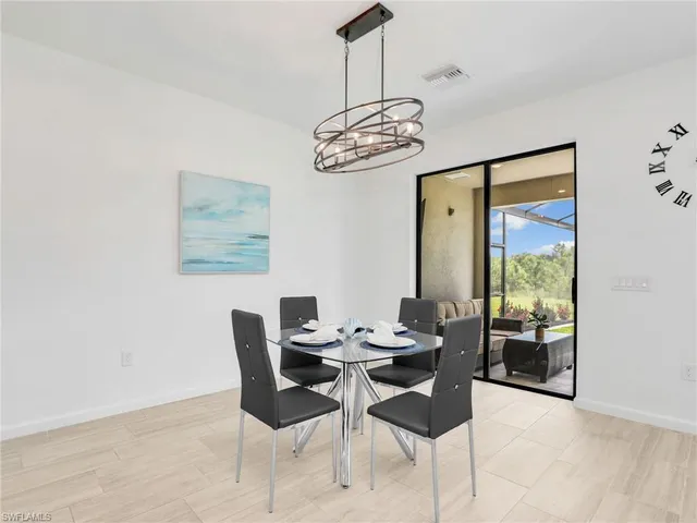 a dining room with furniture a chandelier and window