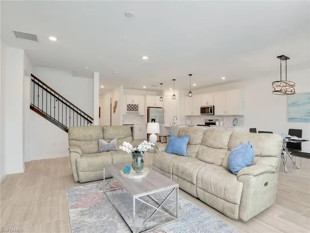 a living room with furniture kitchen view and a dining table