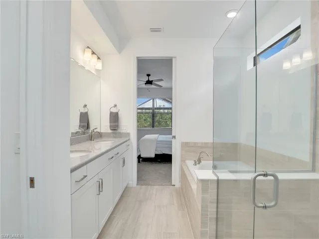 a spacious bathroom with a granite countertop sink a mirror and shower