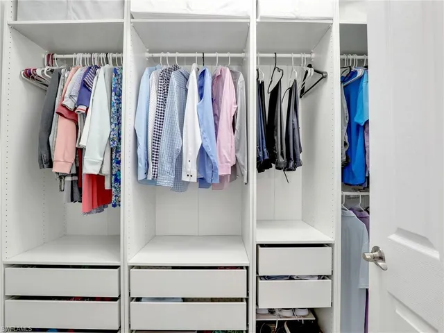 a view of walk in closet with clothes and shoes