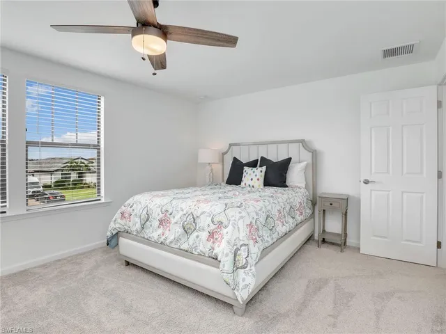 a bedroom with a bed chandelier and window
