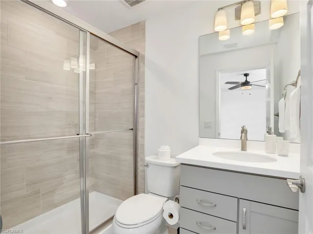 a bathroom with a sink vanity mirror and toilet