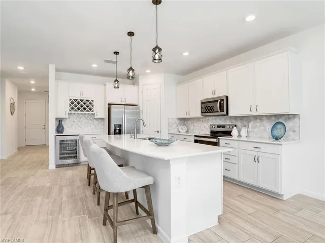 a kitchen with kitchen island granite countertop a sink a counter space appliances and cabinets