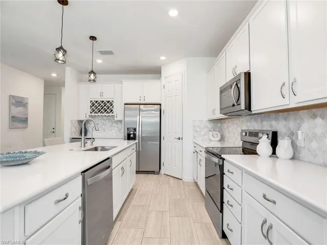 a kitchen with stainless steel appliances granite countertop a sink a stove and a refrigerator