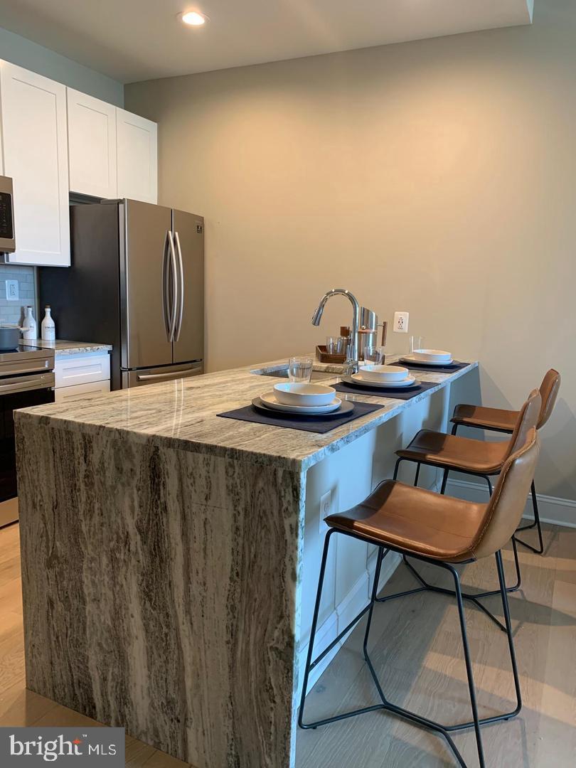 2130 Arch Street, Unit 103 Philadelphia, PA 19103 - Photo 2 of 25 a kitchen with a table chairs and refrigerator