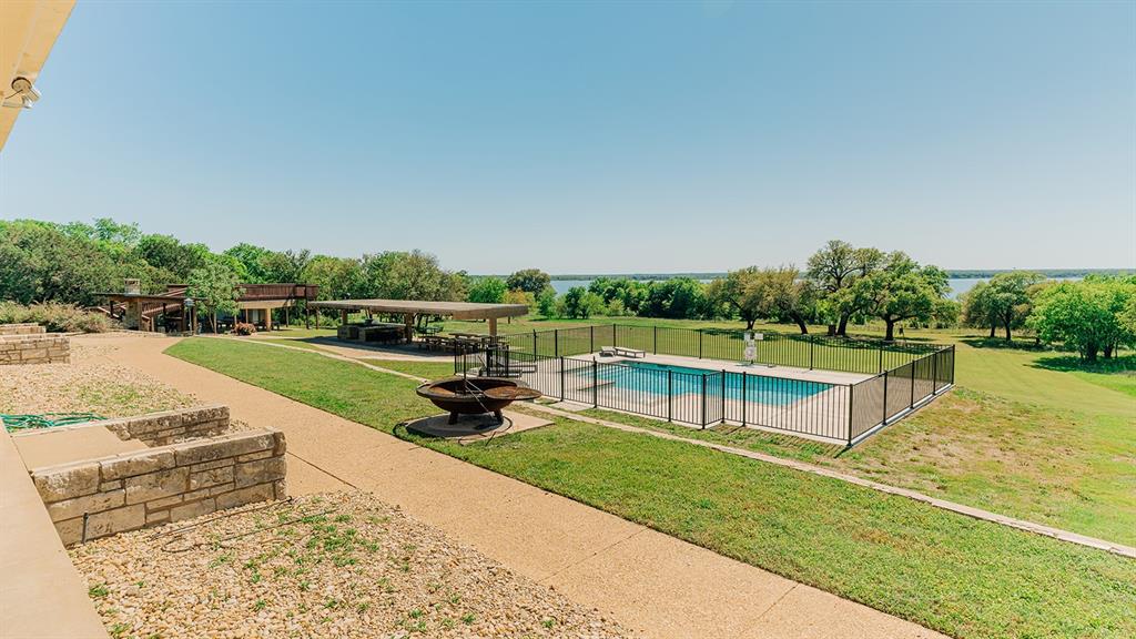 175 Tobacco Road Whitney, TX 76692 - Photo 31 of 35 View of swimming pool featuring a patio area, a fire pit, and view of scattered trees