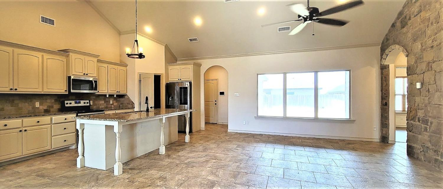 5234 Kemper Street Lubbock, TX 79416 - Photo 4 of 28 a kitchen with stainless steel appliances granite countertop a stove a sink and a refrigerator