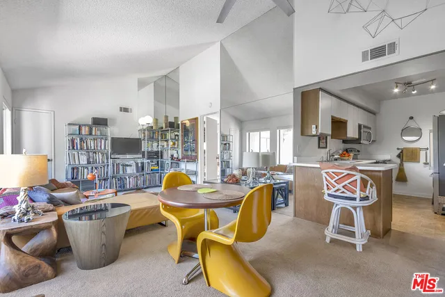 a living room with furniture a flat screen tv and a large window