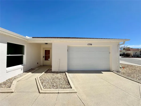 a kitchen with white cabinets appliances a sink and a window