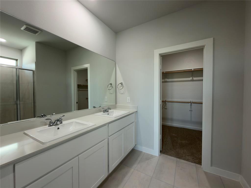120 Millwood Road Lavon, TX 75166 - Photo 26 of 34 Dual vanity featuring white cabinetry, integrated sinks, chrome faucets, and a large wall-mounted mirror