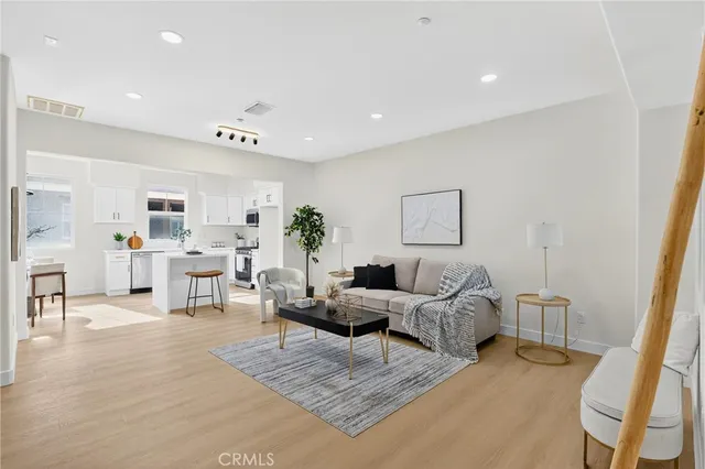 a living room with furniture and view of kitchen