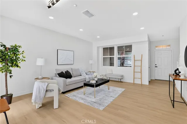 a living room with furniture and potted plants