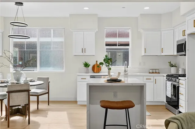 a kitchen with stainless steel appliances granite countertop a sink a stove a window and cabinets