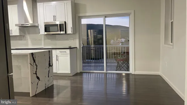 a kitchen with granite countertop a refrigerator and a stove top oven