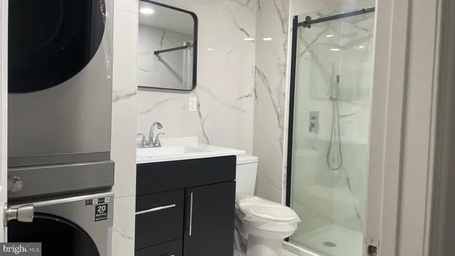 a bathroom with a sink a toilet and shower