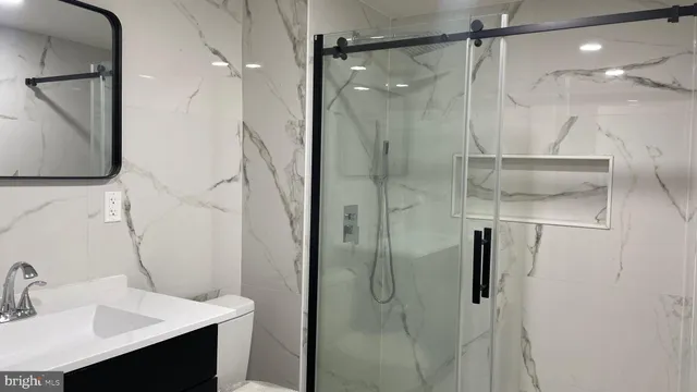 a bathroom with a shower sink vanity and mirror