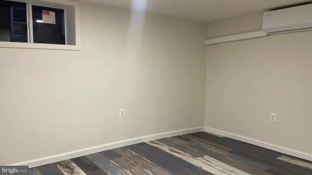 a view of an empty room with wooden floor and closet