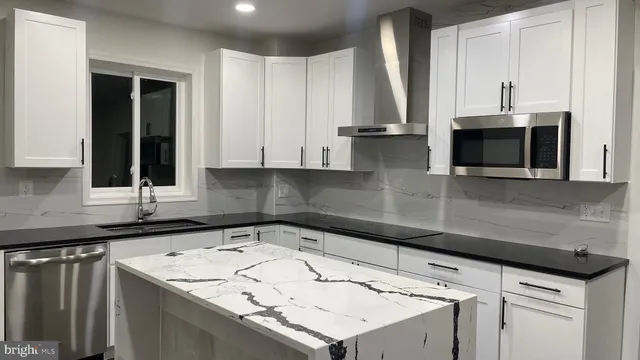 a kitchen with stainless steel appliances a sink a stove and cabinets