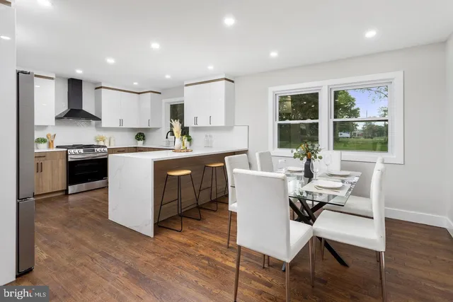 a kitchen with a table chairs a sink dishwasher and cabinets