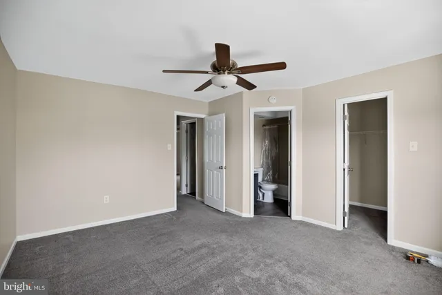 a view of a livingroom with a chandelier fan and windows