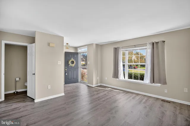 a view of a big room with wooden floor and windows