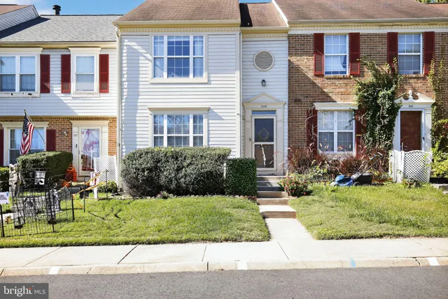 a front view of a house with a yard and potted plants