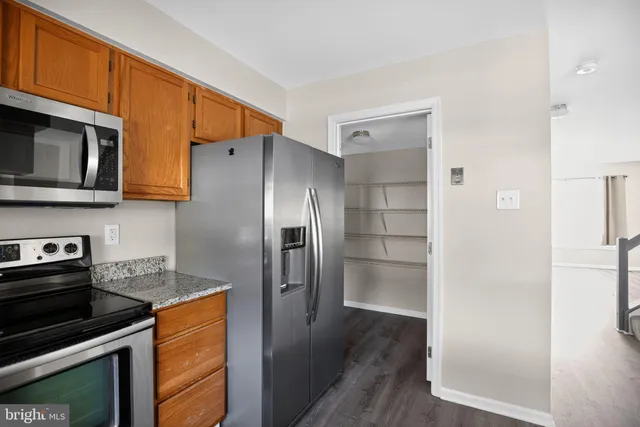a kitchen with stainless steel appliances granite countertop a refrigerator and a stove top oven