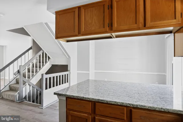 a view of staircase with white cabinets and railing