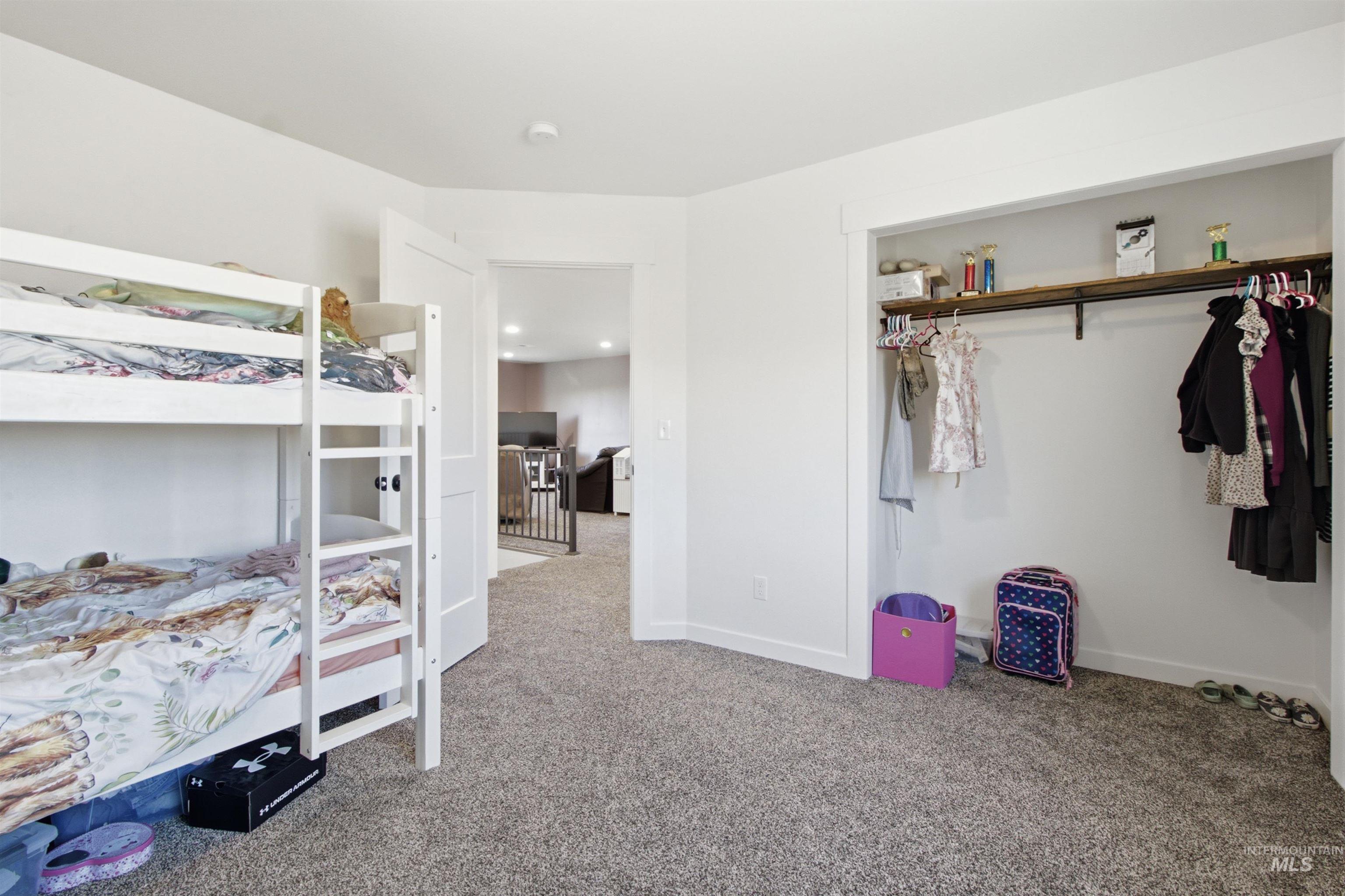 1032 Duffield Flat Road Potlatch, ID 83855 - Photo 33 of 50 Neutral tone wall paint, carpet flooring, open closet with built-in shelving, white trim, and a white interior door