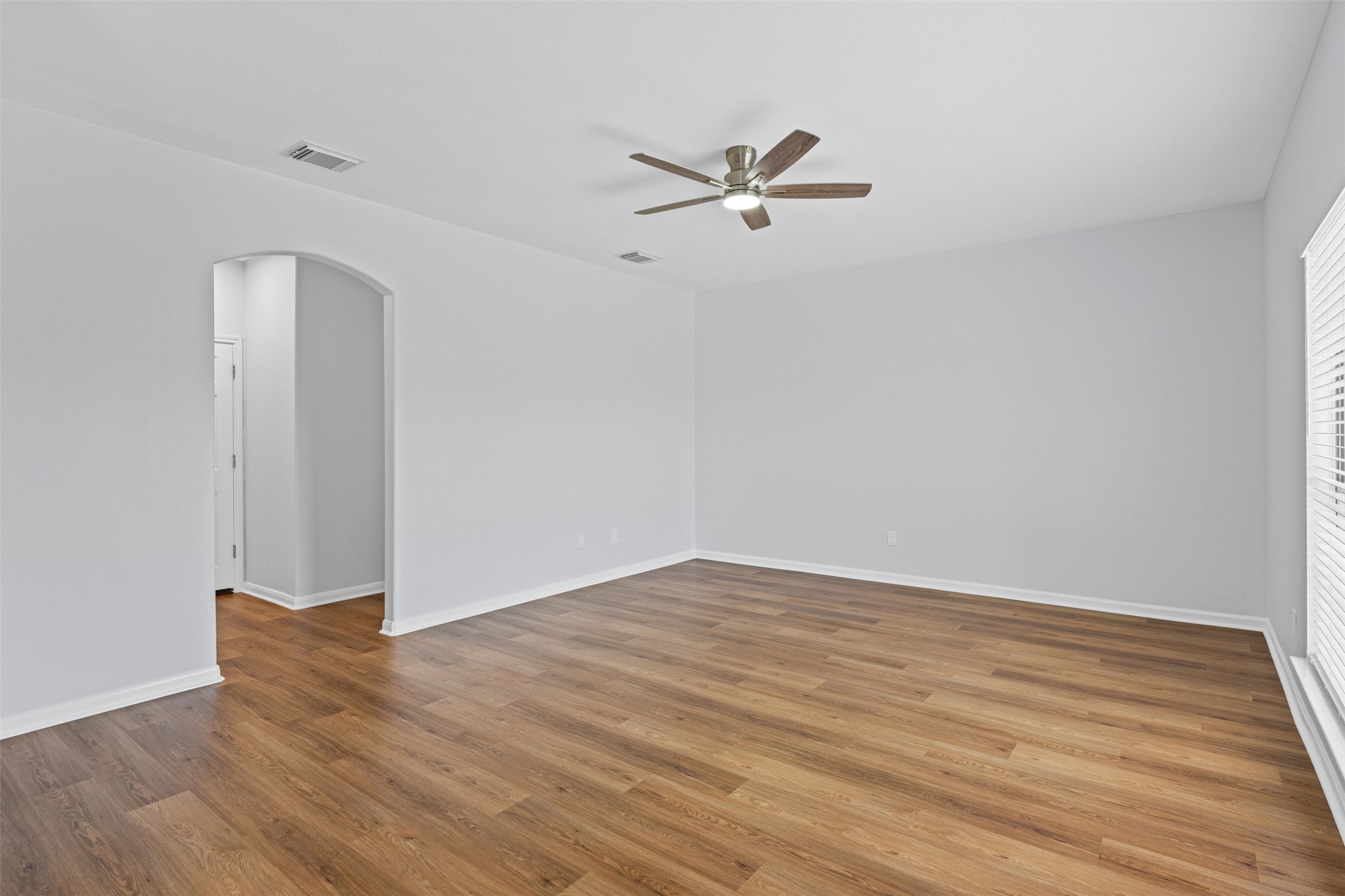 243 Engineers Pass Jarrell, TX 76537 - Photo 14 of 40 Spacious interior featuring wood-finish flooring, light gray wall paint, and white baseboards
