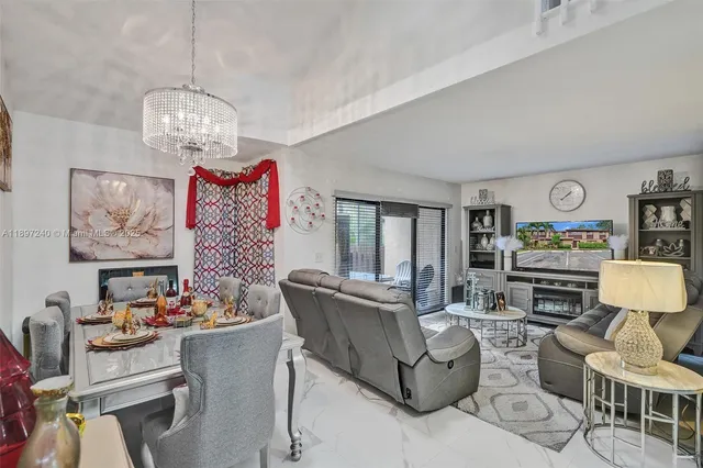 a living room with furniture a dining table and a chandelier