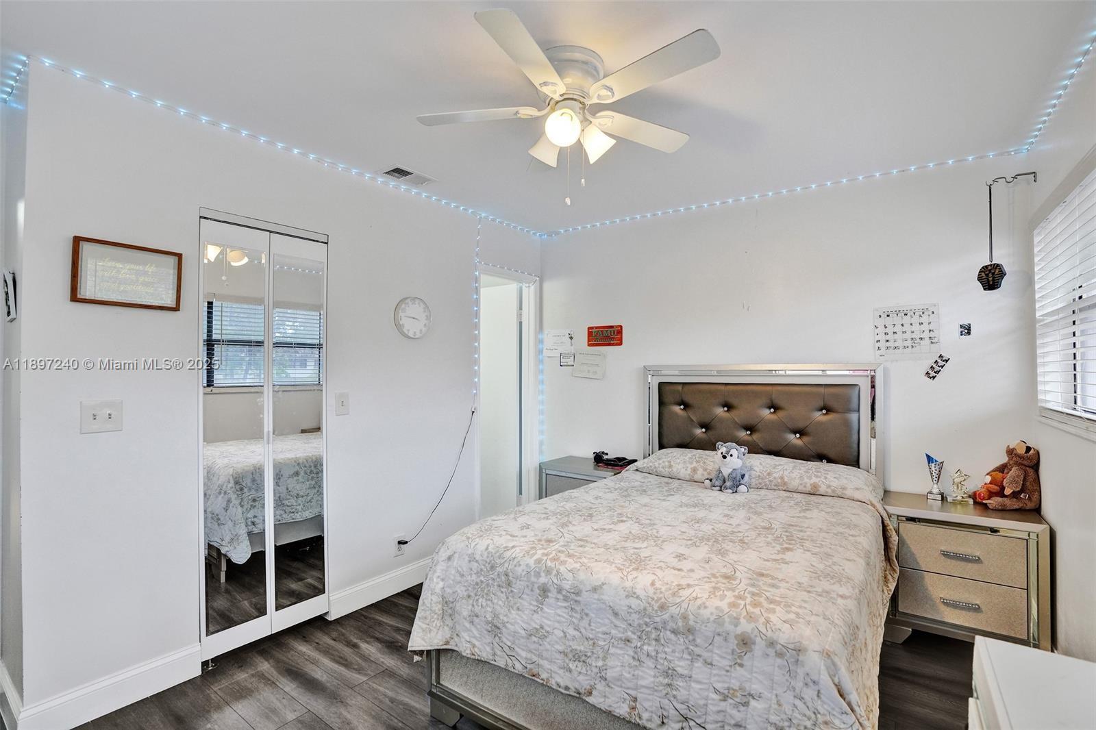 7780 Northwest 79th Avenue, Unit F6 Tamarac, FL 33321 - Photo 20 of 27 a bedroom with a large bed and a chandelier fan