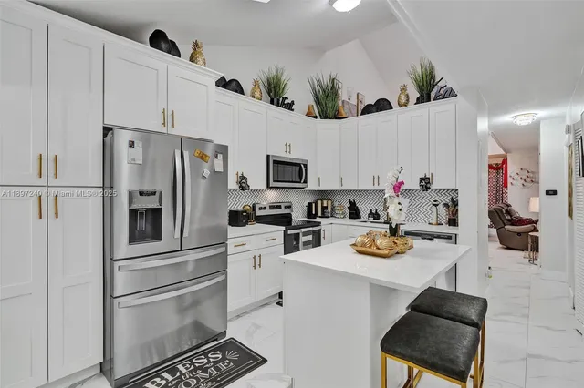 a kitchen with stainless steel appliances a stove refrigerator sink and cabinets