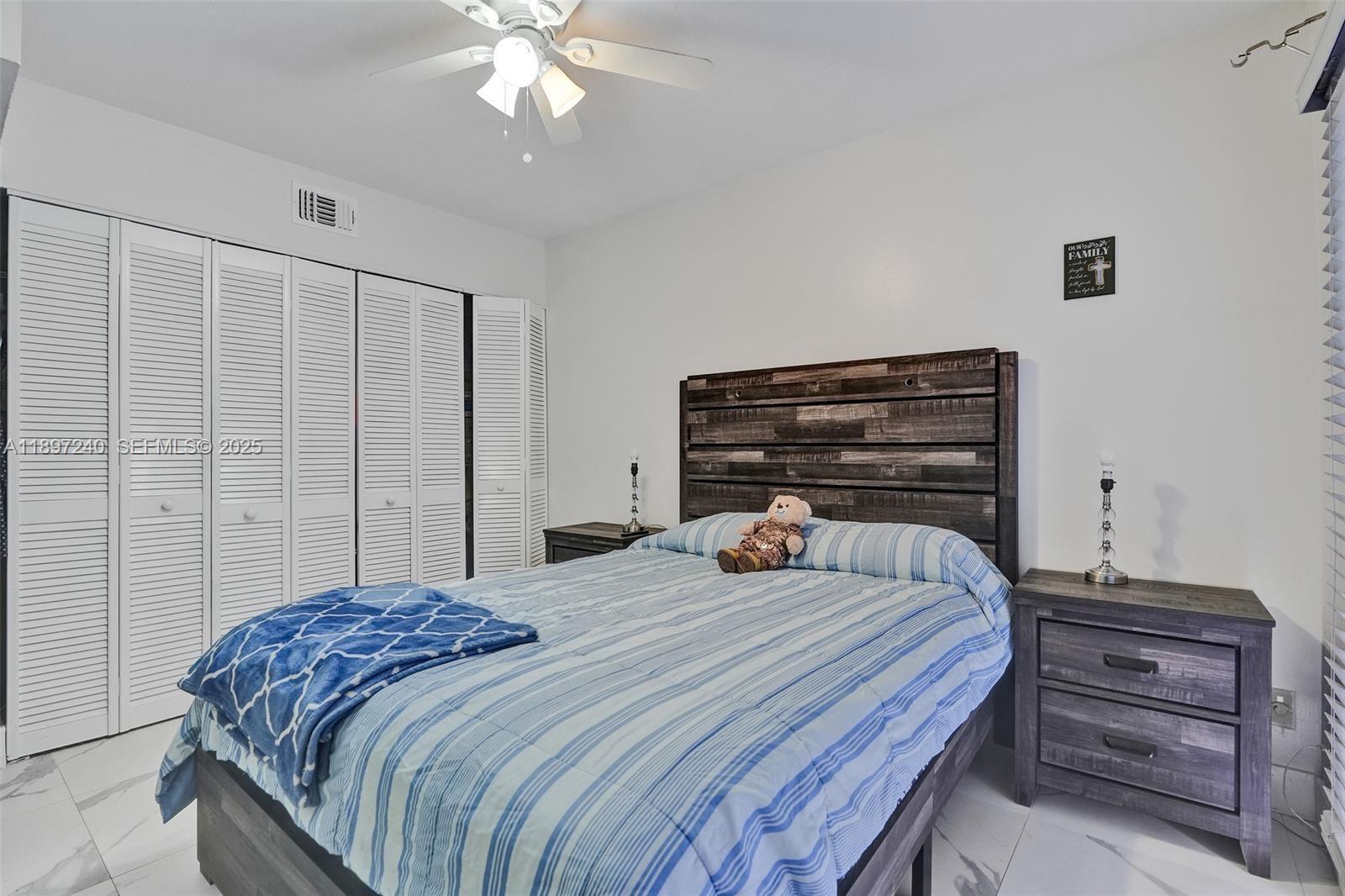 7780 Northwest 79th Avenue, Unit F6 Tamarac, FL 33321 - Photo 23 of 27 a bedroom with a bed and a chandelier