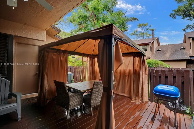 a view of a patio with table and chairs under an umbrella