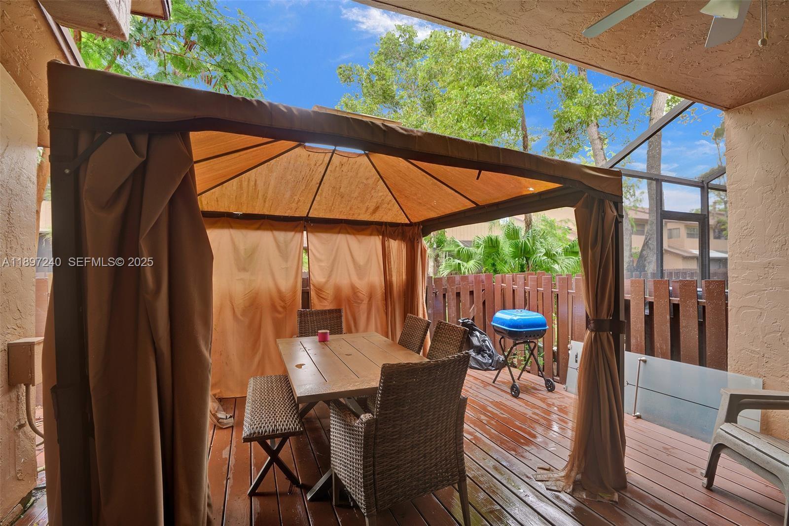 7780 Northwest 79th Avenue, Unit F6 Tamarac, FL 33321 - Photo 26 of 27 a view of a patio with table and chairs under an umbrella