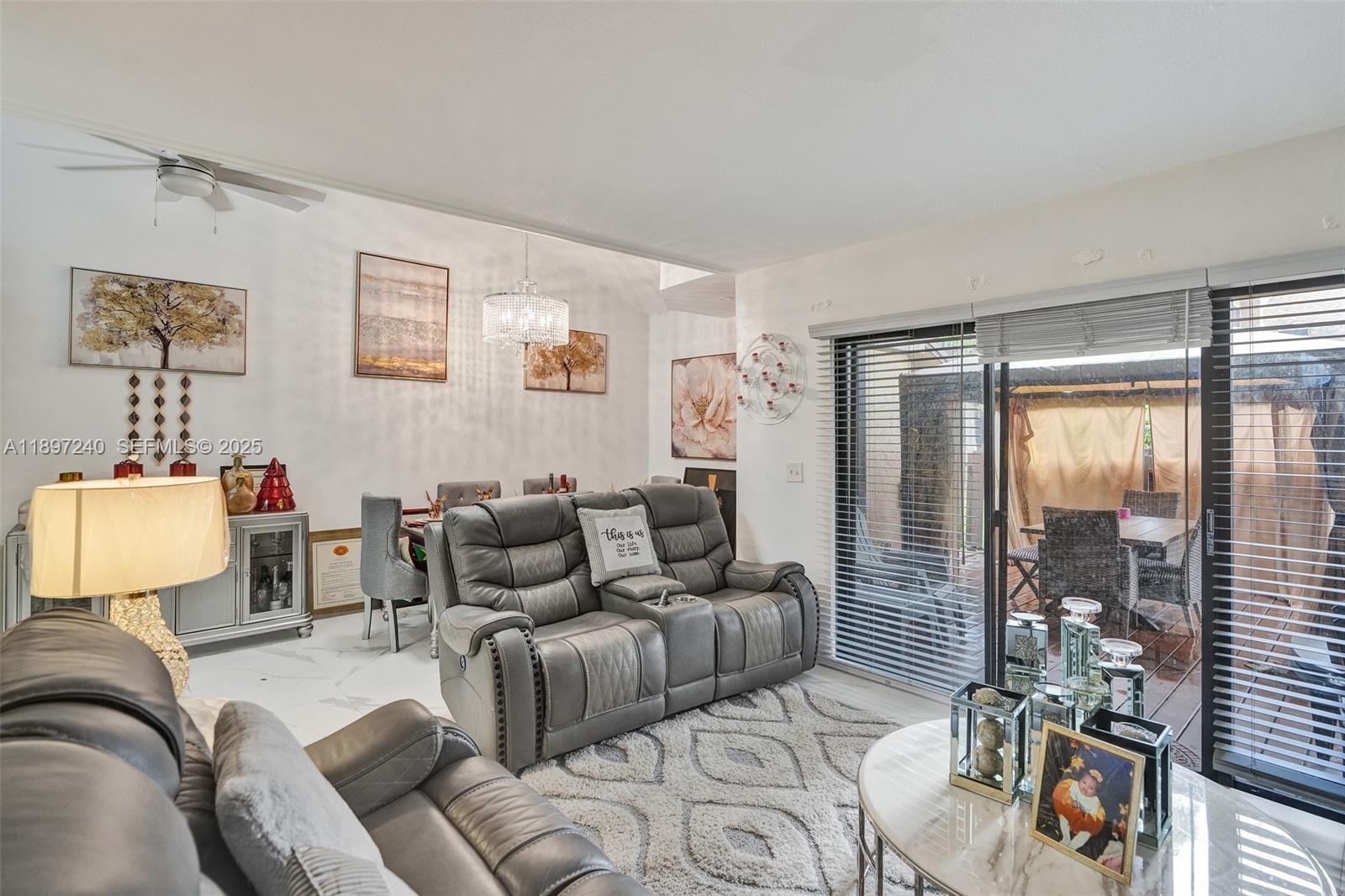 7780 Northwest 79th Avenue, Unit F6 Tamarac, FL 33321 - Photo 8 of 27 a living room with furniture and a floor to ceiling window