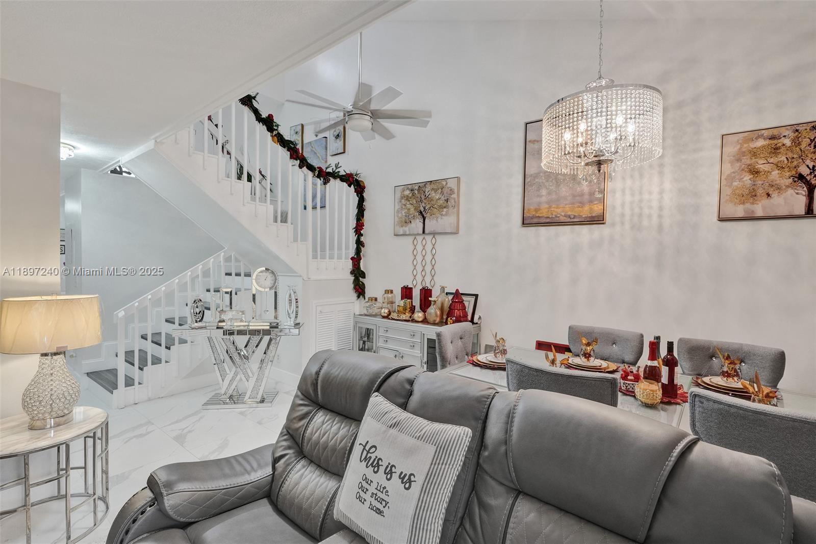 7780 Northwest 79th Avenue, Unit F6 Tamarac, FL 33321 - Photo 10 of 27 a living room with furniture and a chandelier