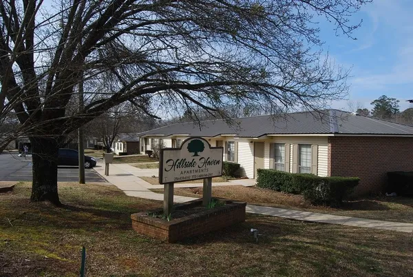 a front view of a house with garden and trees