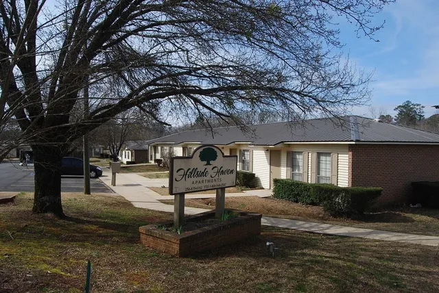 a front view of a house with garden and trees