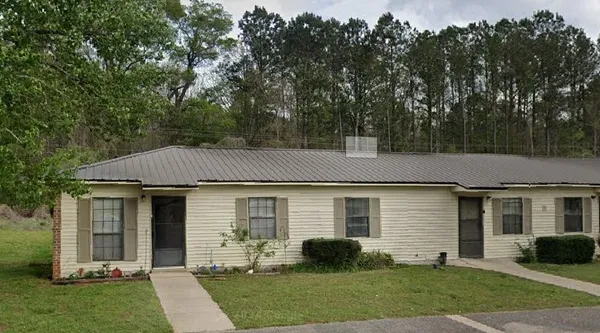 a front view of a house with a yard and outdoor seating