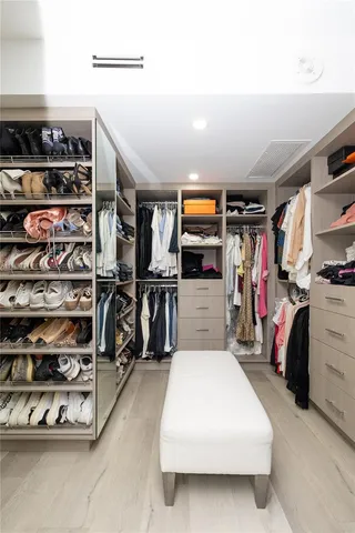 a view of walk in closet with clothes and shoes