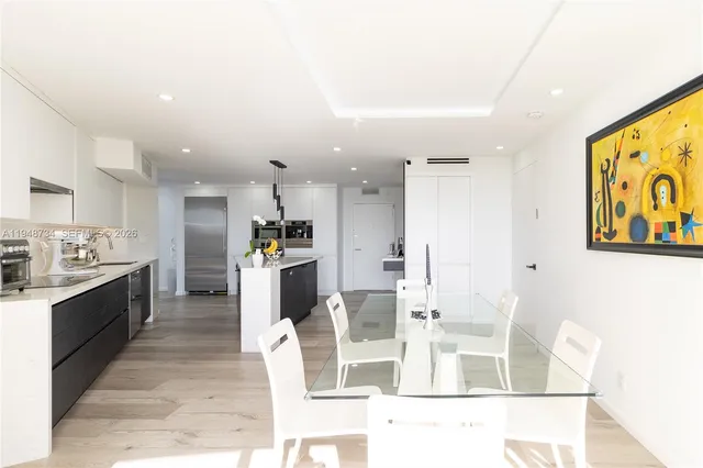 a large kitchen with stainless steel appliances kitchen island granite countertop a refrigerator and cabinets