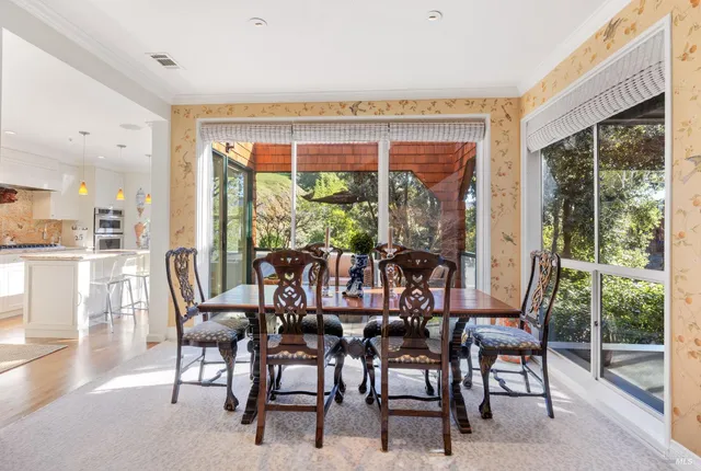 a view of a dining room with furniture large windows and wooden floor